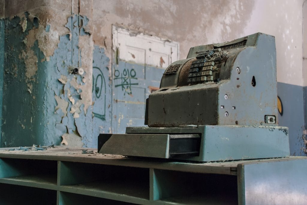 a blue cash register in a sorry state of repair