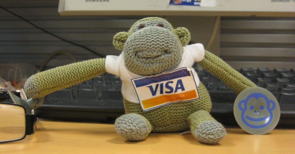 the Payment Monkey sitting on a desk in front of a monitor
