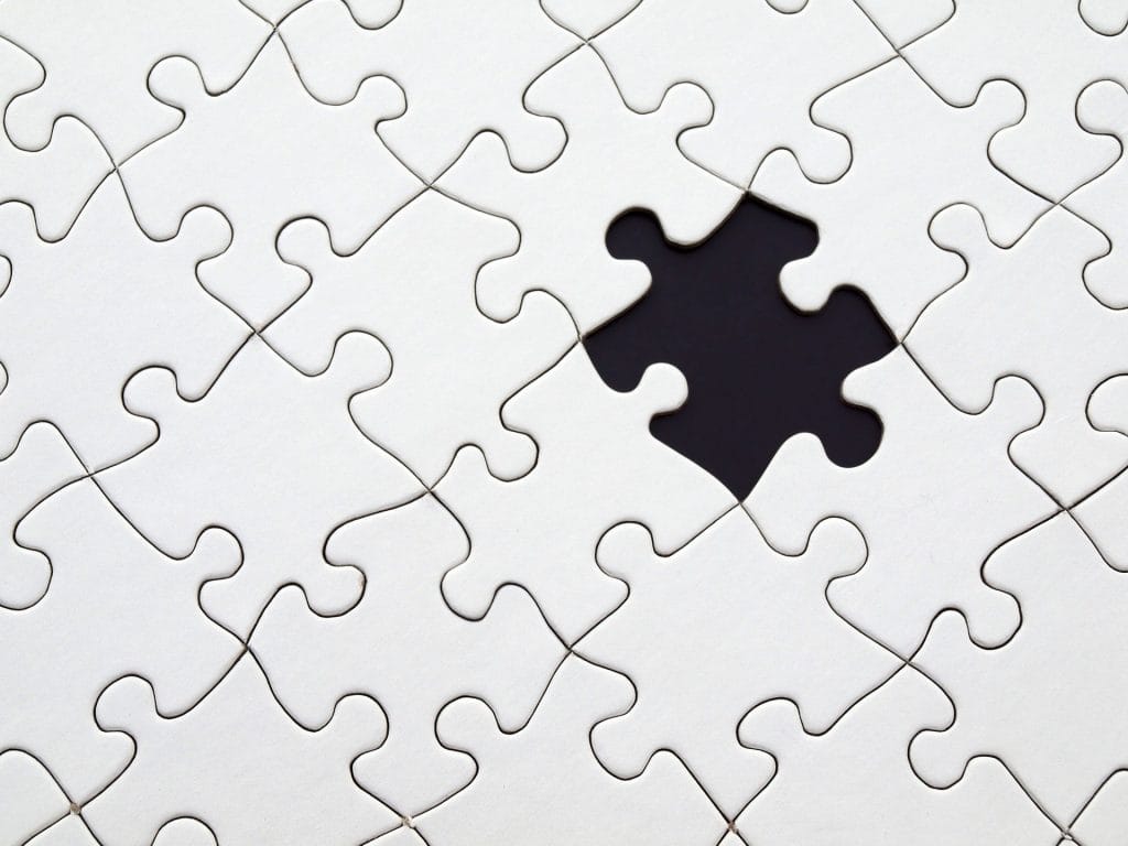 A white jigsaw puzzle with one missing piece