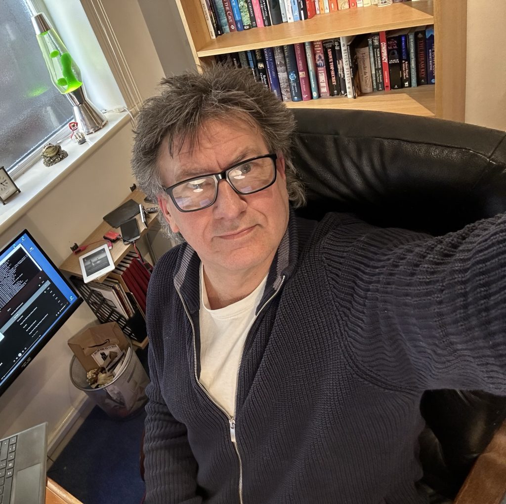 David surrounded by computers and bookcases