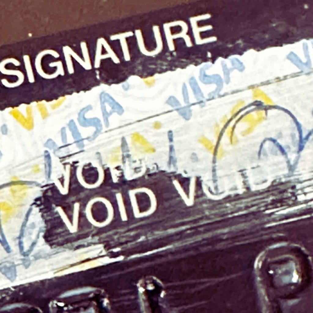 A signature panel on the back of a payment card showing the VOID indicators